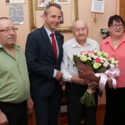 Paweł Kołek na zdjęciu z bukietem urodzinowych kwiatów.